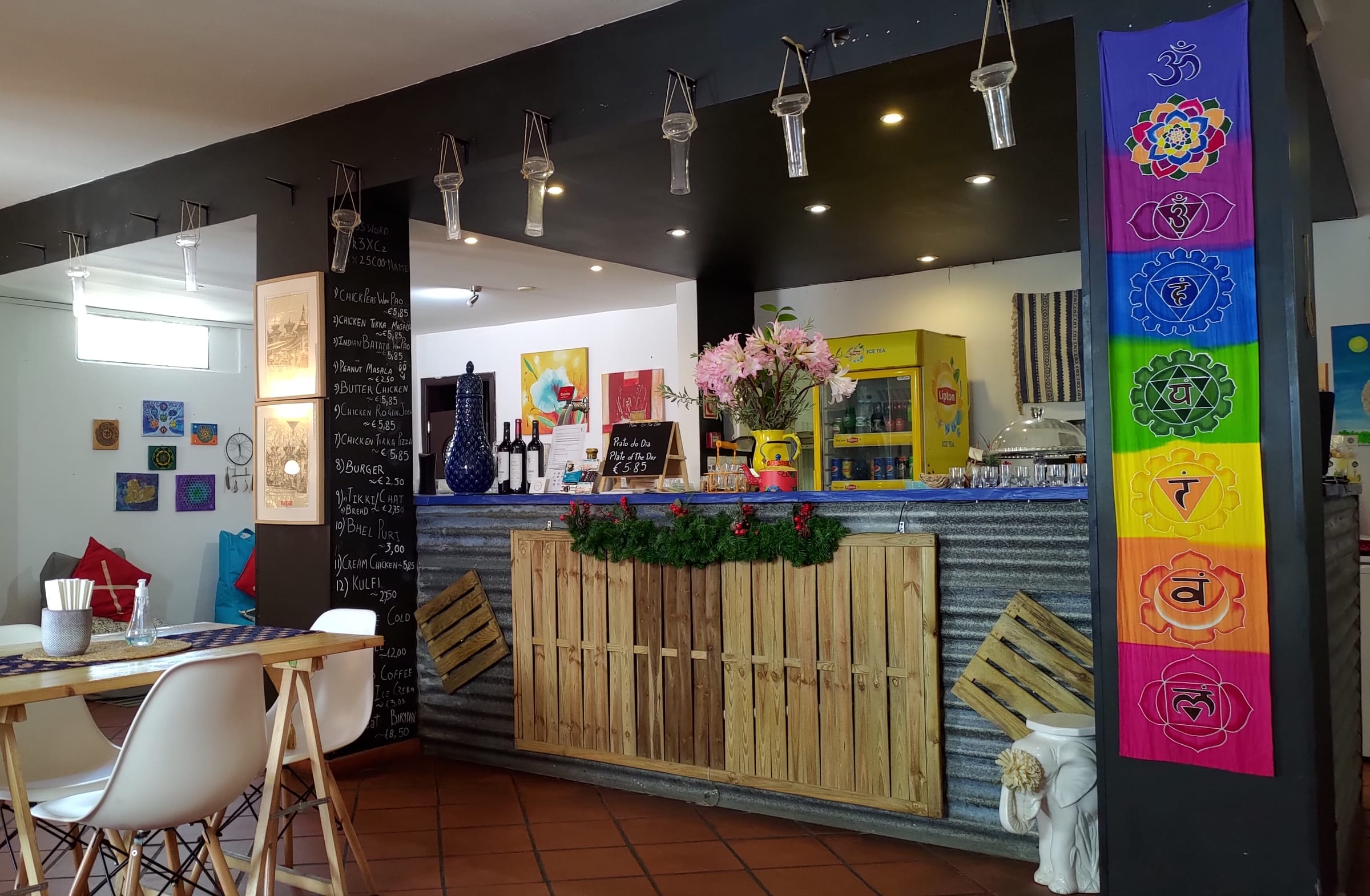 Sala do Flavours of India, com mesas postas e arte nas paredes